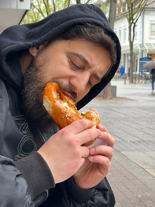 Man enjoys pretzel and coffee in downtown Kehl, Germany