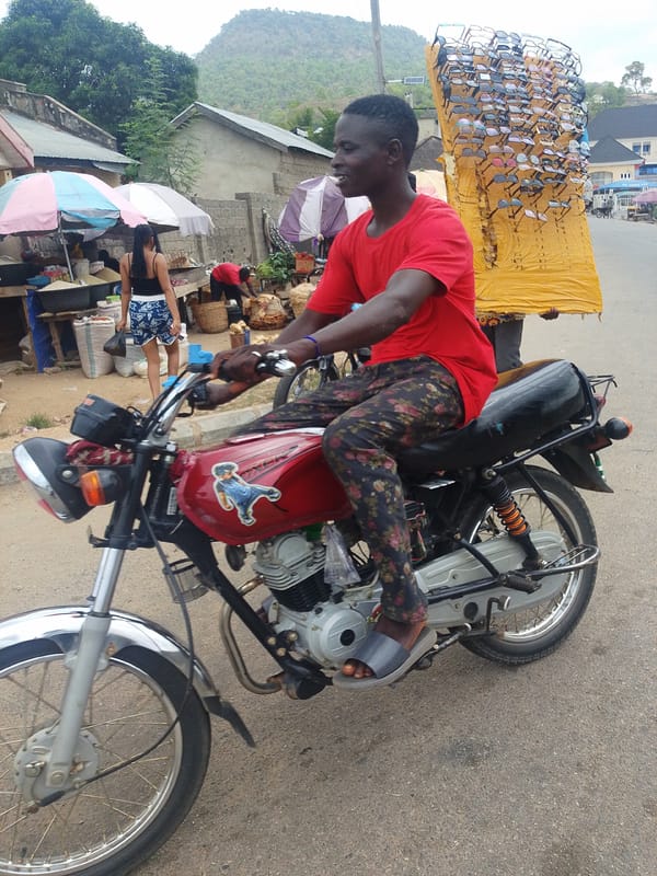 Motorcycle rider and pedestrian share urban street scene