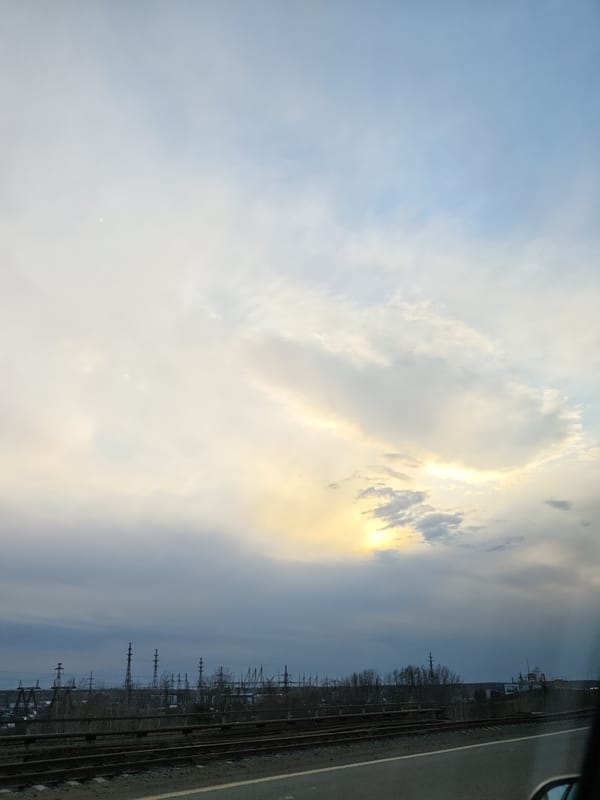 Industrial landscape and waterway observed from moving vehicle in Chaikovsky