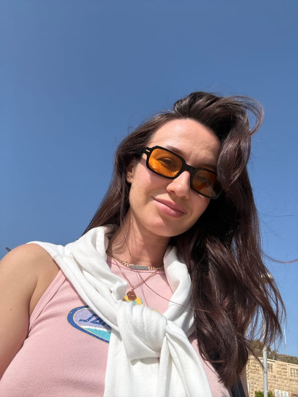 Woman takes selfie on busy Tel Aviv beach afternoon