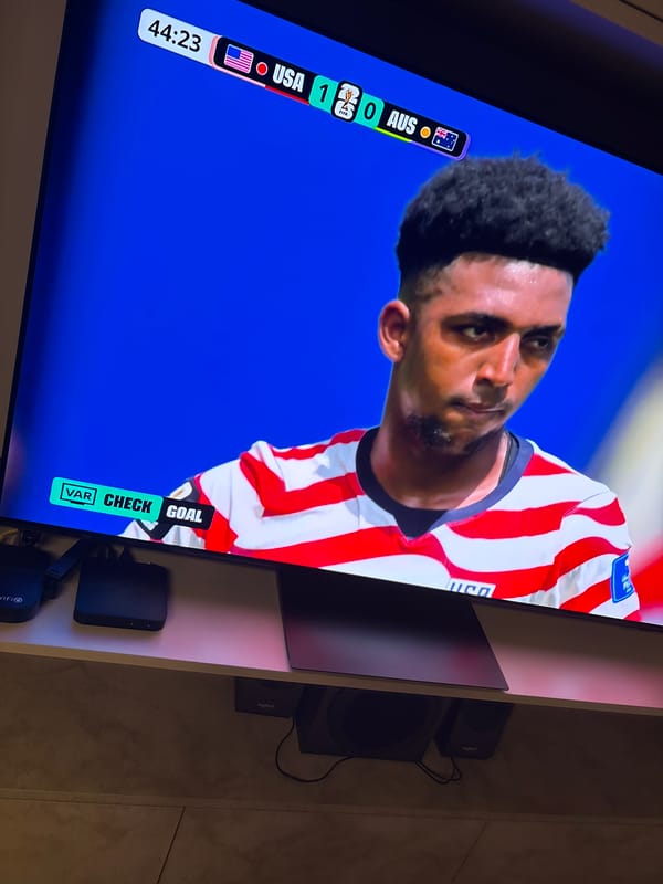 USA vs Australia on TV, CRM open on a laptop — Burgas evening