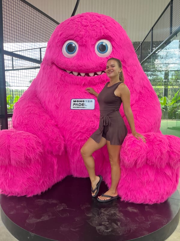 Woman poses with pink monster statue at Indonesian sports facility