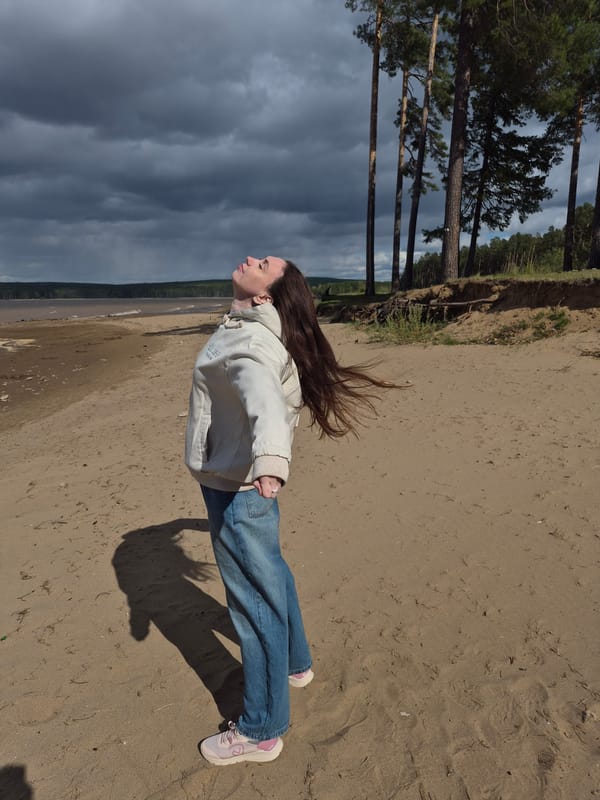 Woman enjoys brief riverside visit during changing weather in Chaikovsky