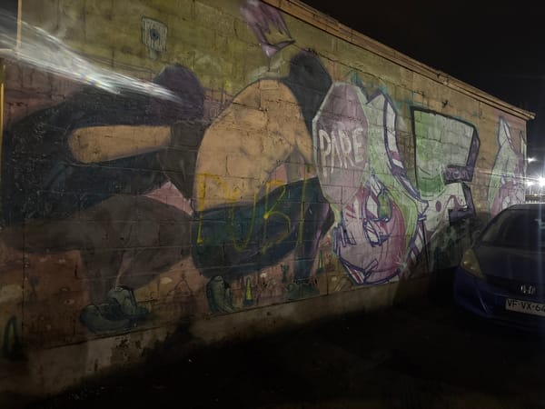 Late night urban scenes documented: graffiti, pizza, parked cars