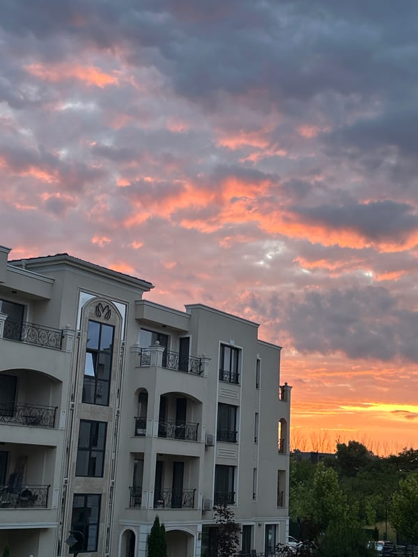 Dramatic sunset documented over Plovdiv apartment buildings with balcony flowers