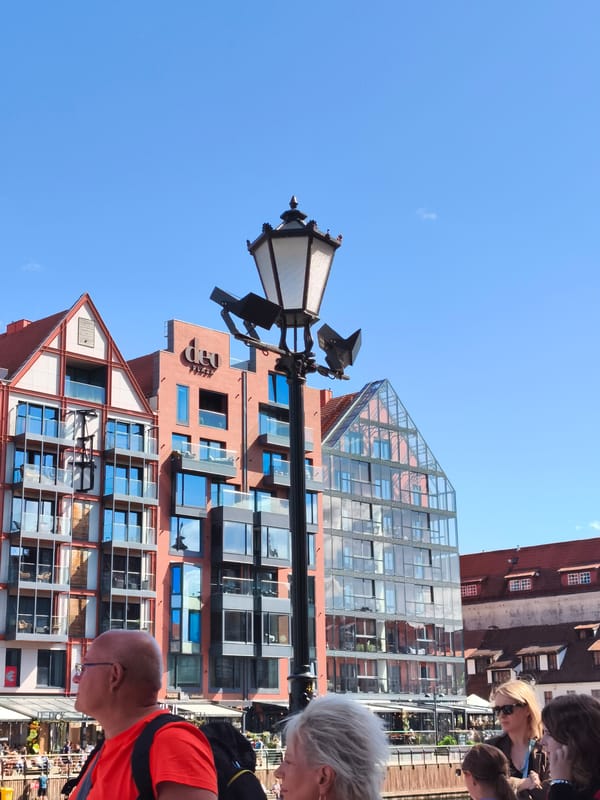Ornate streetlamp against modern Gdańsk skyline
