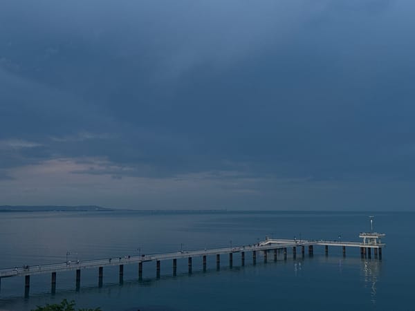Evening strollers gather at Burgas Bridge pier during twilight