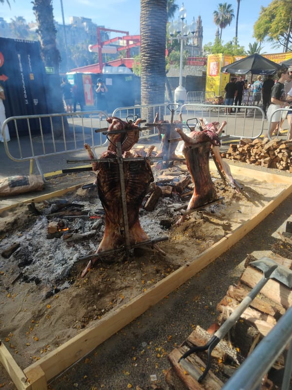 Outdoor festival with roasted pigs and marina views in Barcelona