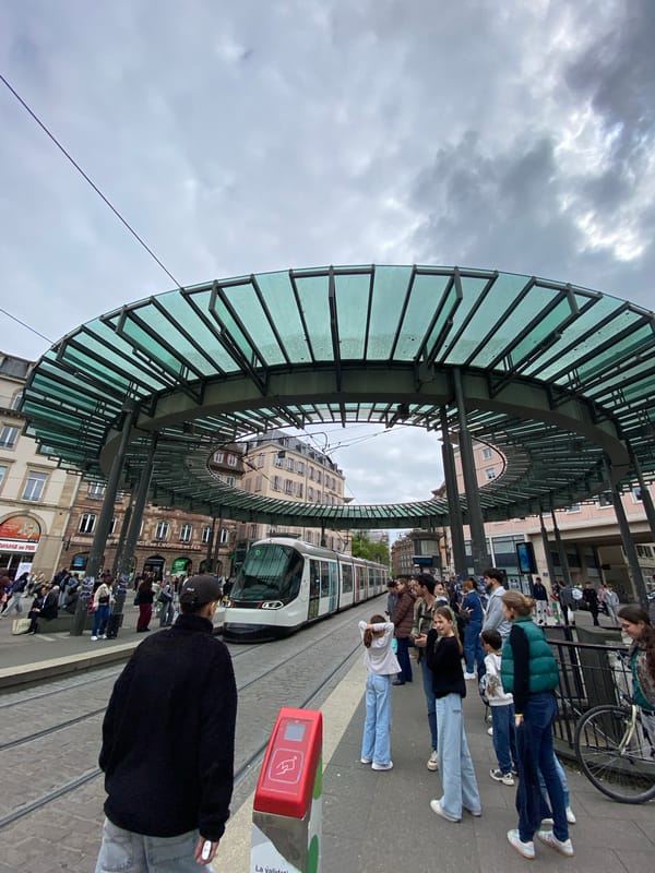 Crowd gathers near Strasbourg tram stop during midday