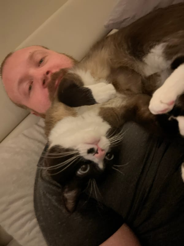 Man cuddles tuxedo cat in Russian home