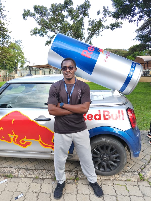 Man poses with Red Bull-branded Mini Cooper in Nairobi