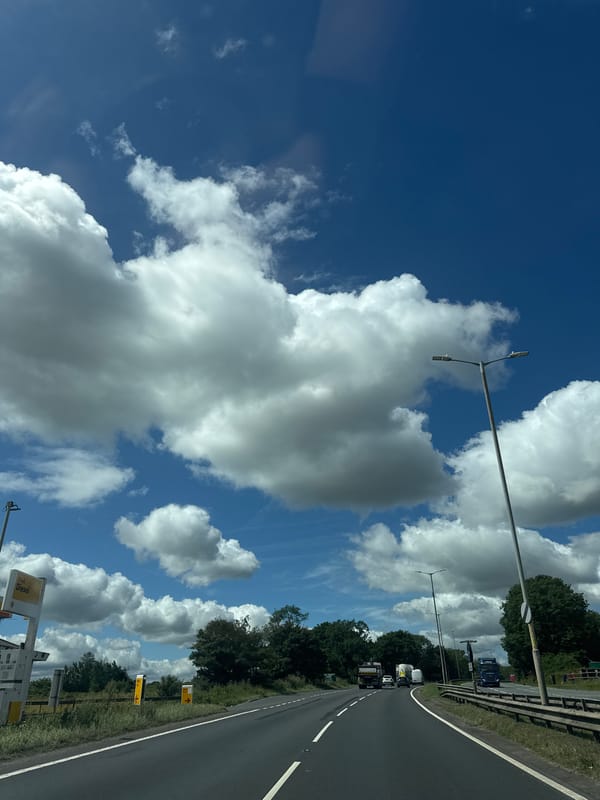 Trucks rolling down an open highway under a blue sky