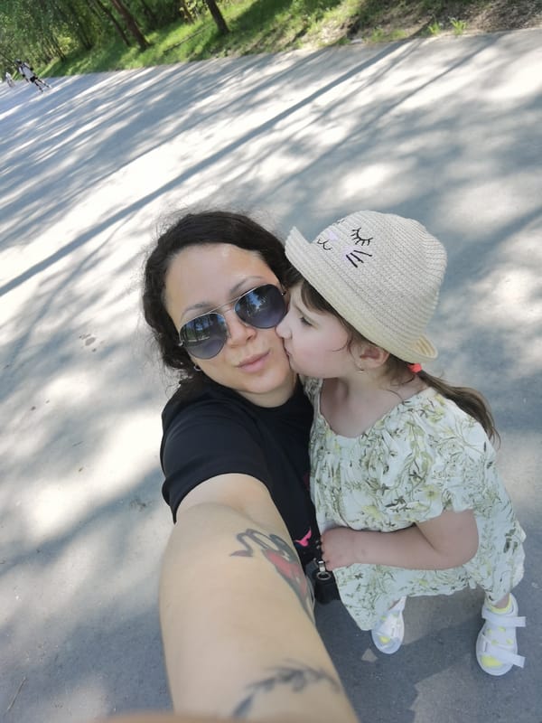 Mother and daughter visit wooden animal sculptures in Perm park