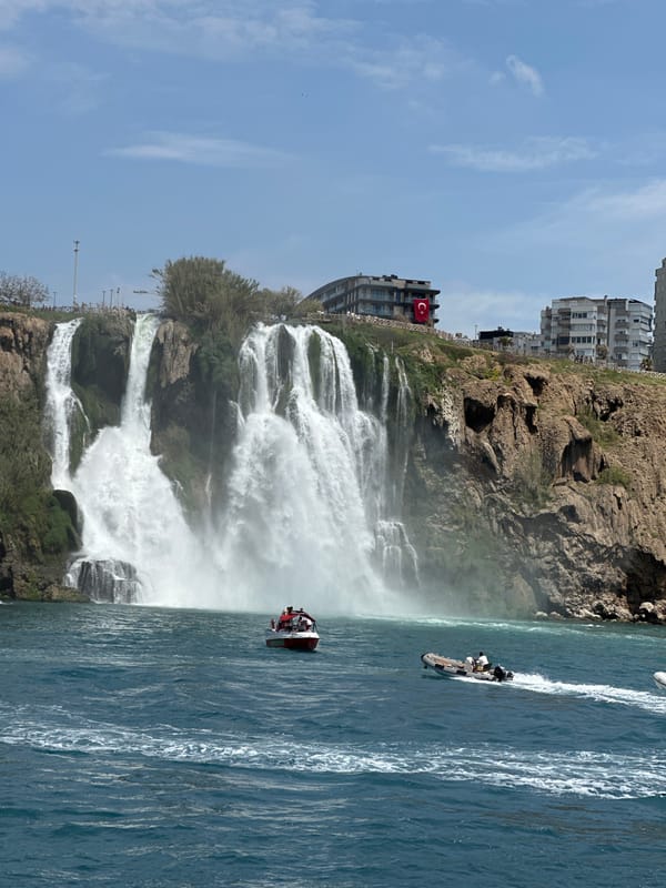 Tourist documents Düden Waterfall cascading into Mediterranean from boat