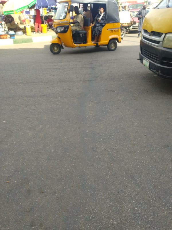 Street life, parked tricycles, trucks, and a mural in progress