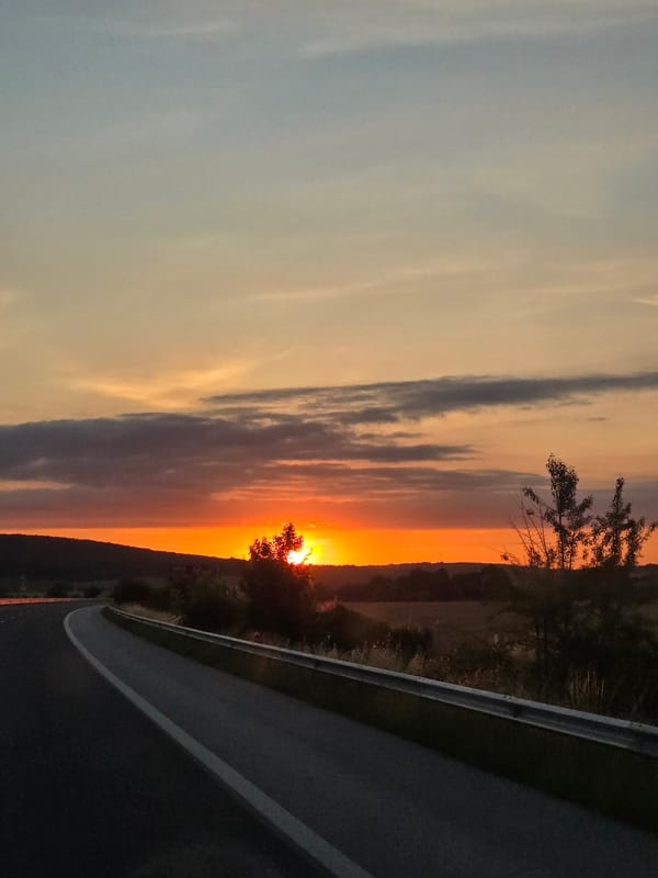 Driving into a rural sunset along an open highway
