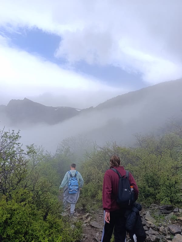 Morning hikers traverse foggy mountain trail near Kalofer, Bulgaria