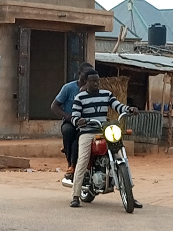 Red motorcycle moving through the streets of Tempure, Nigeria