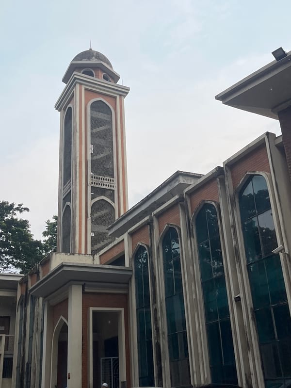 Crypto charts and a mosque minaret, Dhaka midmorning