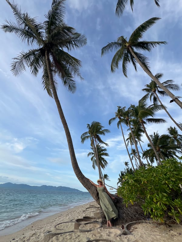 Beach day at Baan Tai: palm trees, kayaking, and shoreline activity