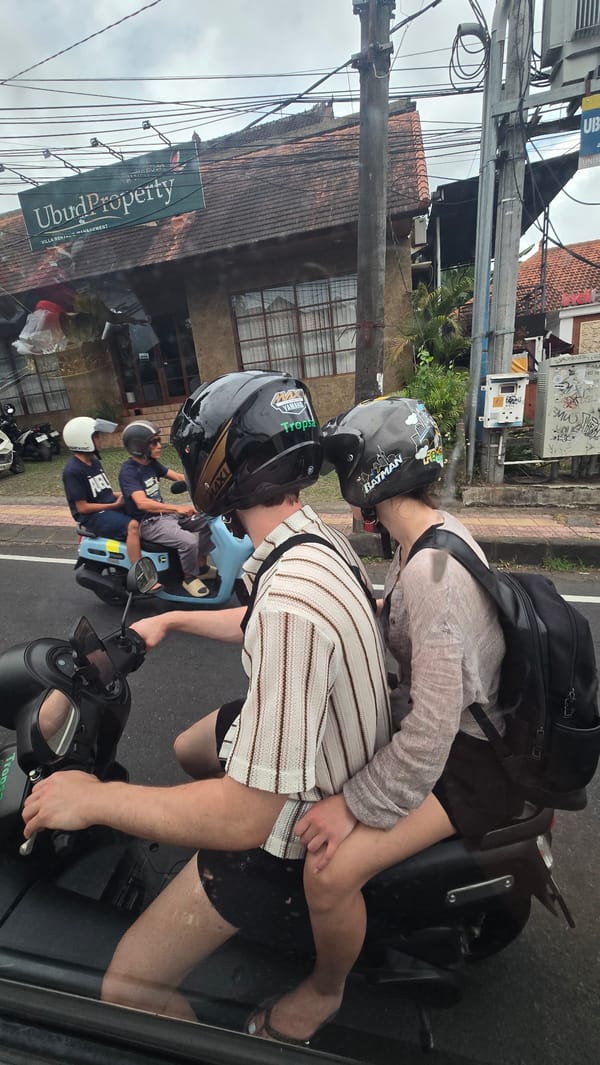 Early morning street activity documented around Balinese statue in Ubud
