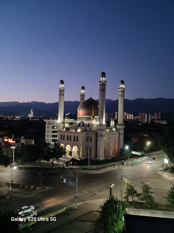 Almaty's Central Mosque glows at dusk against a colorful sky.
