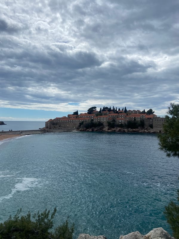 Tourist explores Montenegro's Sveti Stefan resort with pet dog