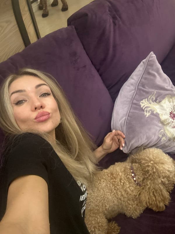Woman relaxes with poodle on purple couch in Armavir