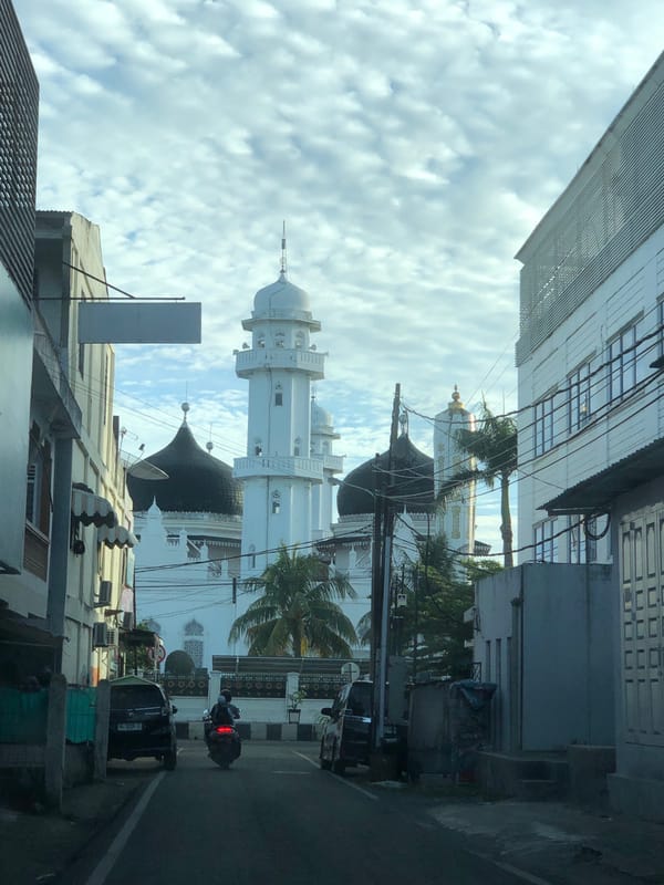 Banda Aceh mosque with white walls, black domes, and golden minarets