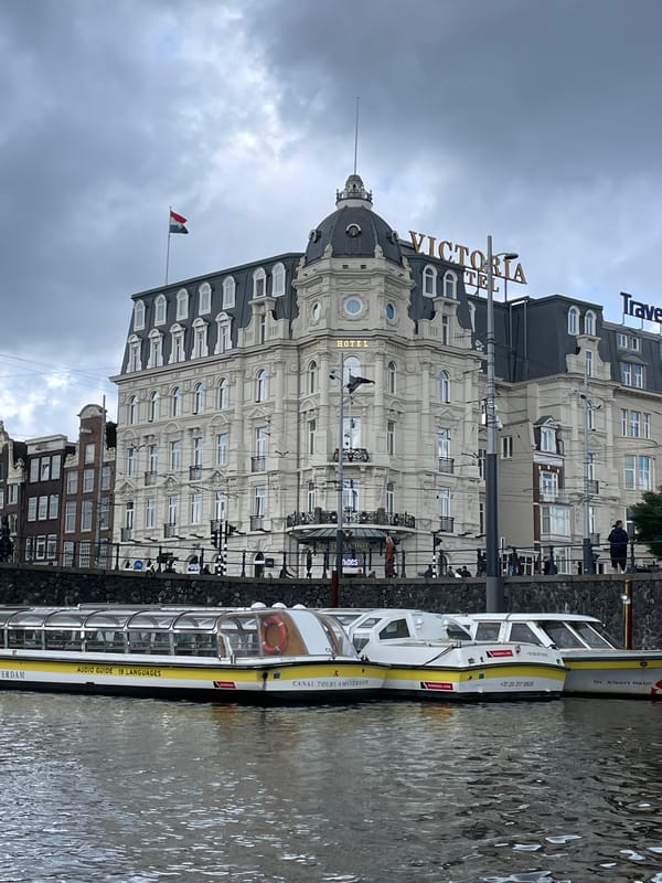 Tourist documents Amsterdam canal tour on overcast morning