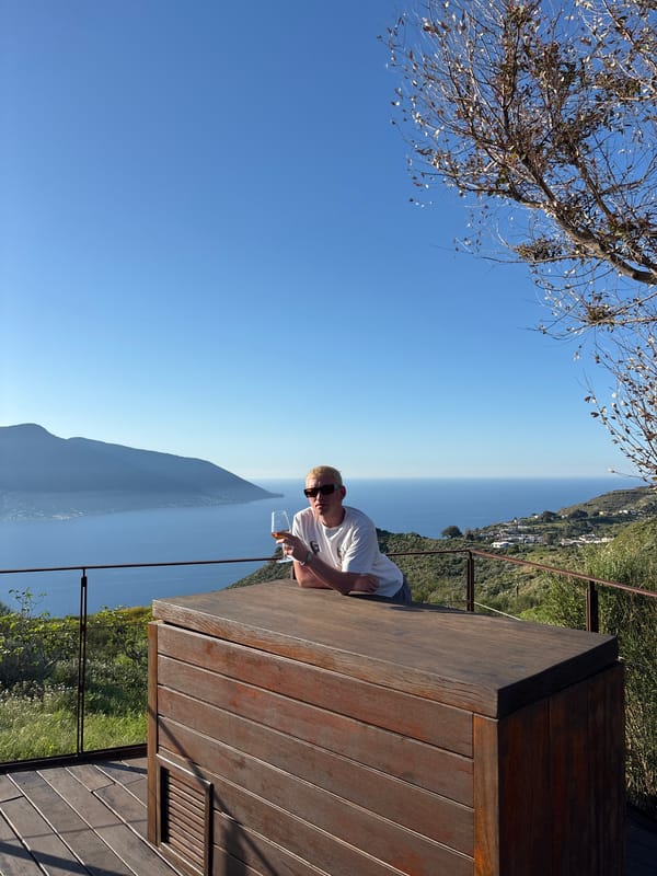 Woman enjoys scenic drink on Lipari terrace overlooking sea