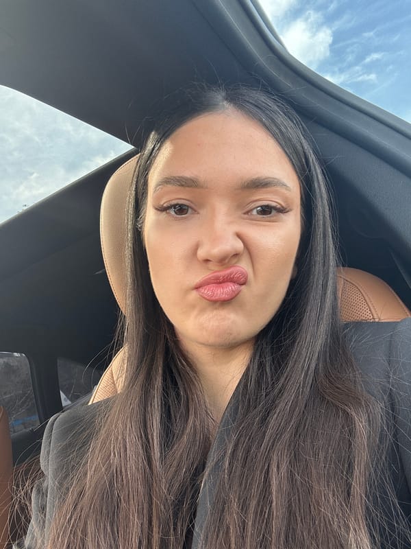 Woman makes kissing face in car with open sunroof