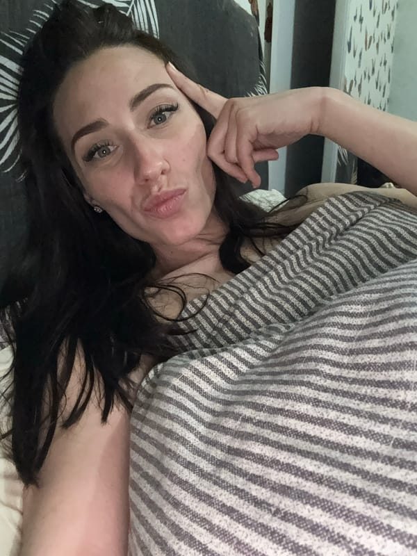 Woman enjoys pastries, rests on striped bed in Saint Petersburg