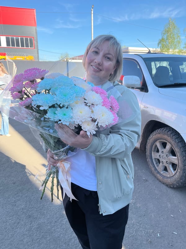 Woman holds flower bouquet in Izhevsk street scene