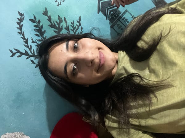 Selfie in front of a teal wall with pagoda mural