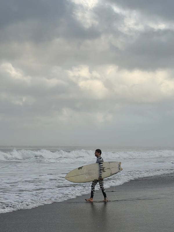 Late night surfer spotted on overcast Kediri beach