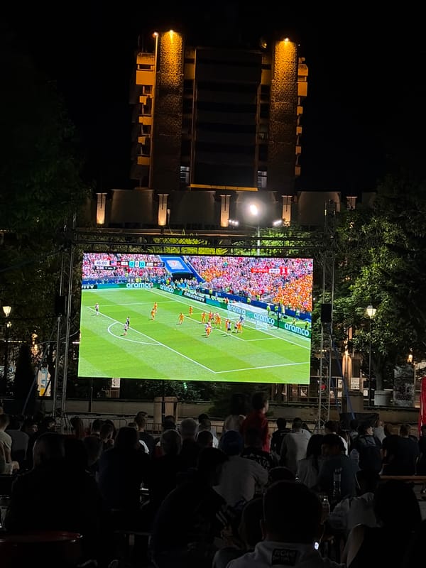 Outdoor soccer screening and a crescent moon through stormy clouds