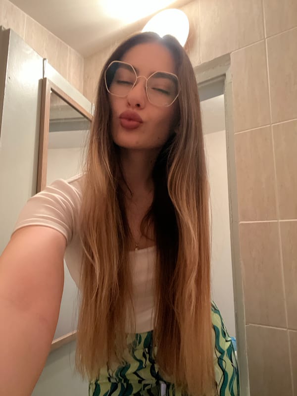 Woman takes bathroom selfie with eyes closed