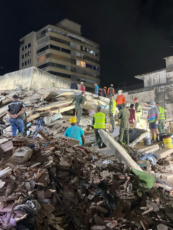Rescue workers dig through collapsed building rubble in Caracas