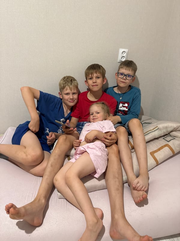 Four siblings captured lying together on bed in Russia