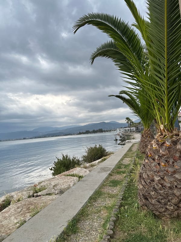 Tourist photographs herself at Fethiye waterfront during early morning