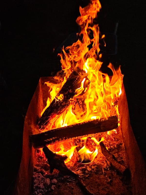 Evening bonfire burns in metal brazier in Парэчча, Belarus