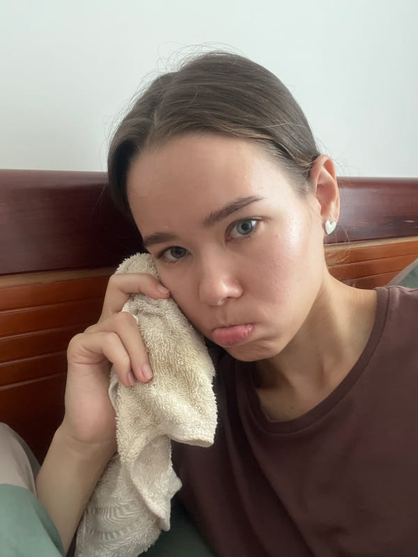 Woman holds towel to face at Vietnam heritage site