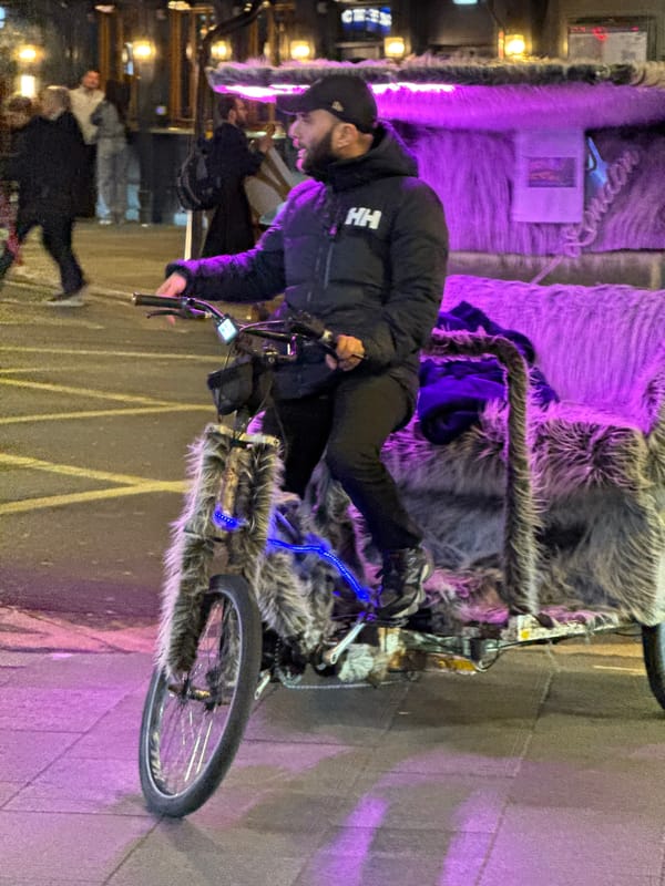 Cyclist rides LED-lit fur-covered bike through central London streets