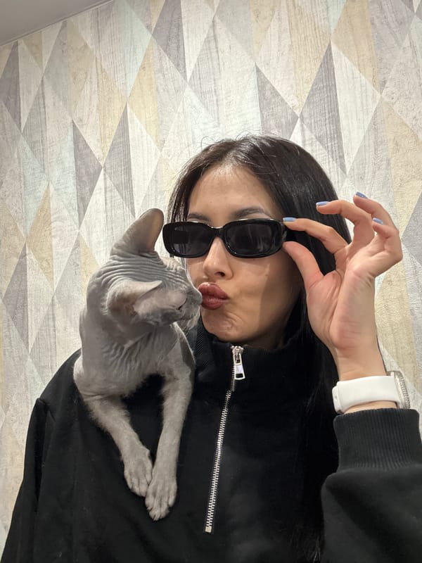 Woman poses with Sphynx cat in indoor photoshoot