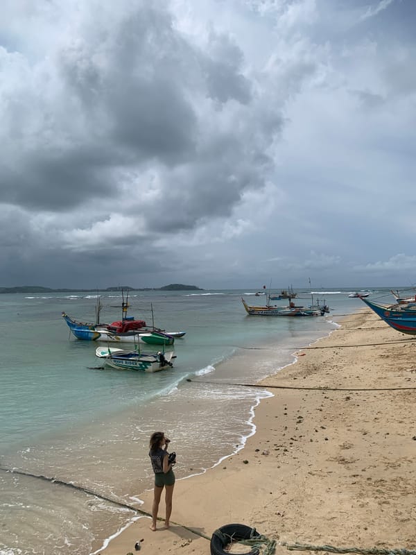 Woman walks beaches amid fishing boats in southern Sri Lanka