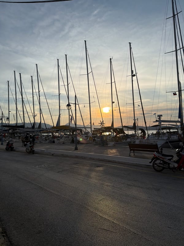 Golden sunset illuminates sailboat marina in Poros, Greece