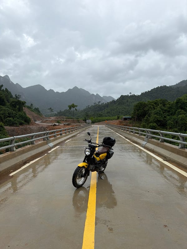 Parked motorcycle on a wet mountain bridge, Trường Sơn