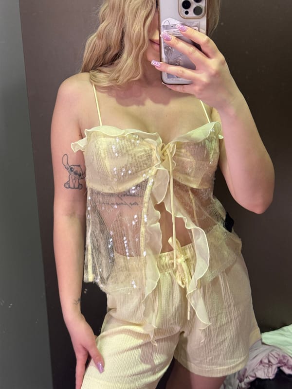 Fitting room mirror selfie in a sheer yellow sequined outfit