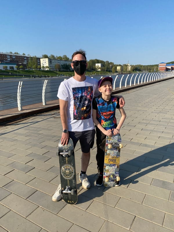 Father and son skateboarding by waterfront in Votkinsk